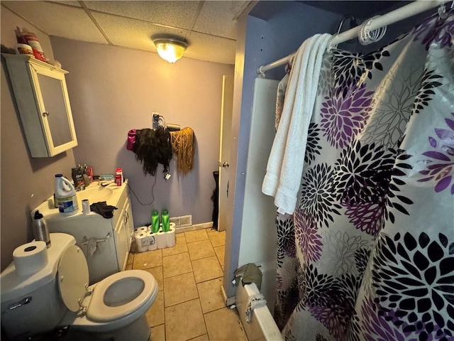 bathroom with a paneled ceiling, tile patterned flooring, a shower with curtain, toilet, and vanity