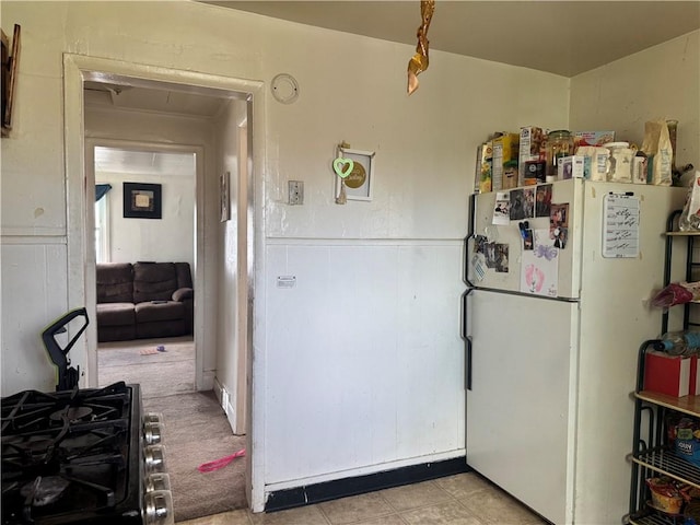 kitchen featuring freestanding refrigerator and wainscoting