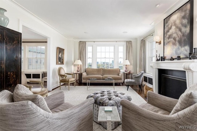 living room with crown molding, a fireplace, plenty of natural light, and baseboards