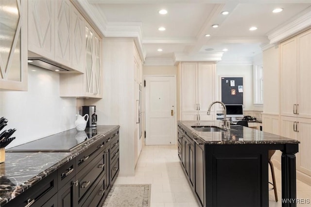 kitchen featuring a sink, crown molding, recessed lighting, dark stone countertops, and a center island with sink