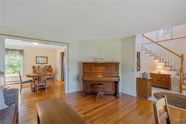4268 Colorado Run, Onondaga, NY 13215 - living area featuring light wood-type flooring, stairway, baseboards, and a baseboard heating unit