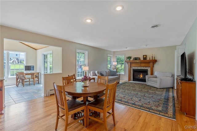 4268 Colorado Run, Onondaga, NY 13215 - dining space with a baseboard heating unit, light wood-style flooring, a glass covered fireplace, a desk, and recessed lighting