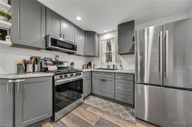 11965 Clinton St, Marilla, NY 14004 - kitchen featuring appliances with stainless steel finishes, a sink, gray cabinets, light wood-style floors, and recessed lighting