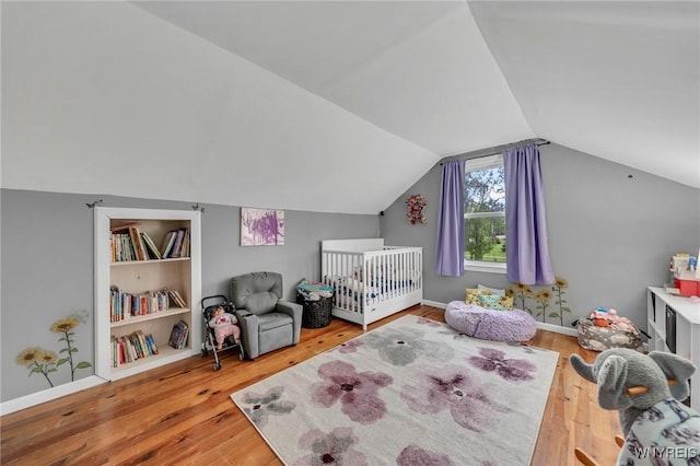 11965 Clinton St, Marilla, NY 14004 - bedroom featuring wood-type flooring, lofted ceiling, baseboards, and a crib