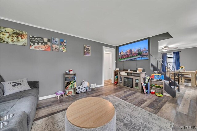 11965 Clinton St, Marilla, NY 14004 - living room featuring wood finished floors, stairs, baseboards, ceiling fan, and ornamental molding