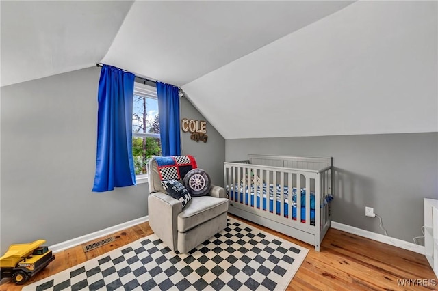 11965 Clinton St, Marilla, NY 14004 - bedroom with vaulted ceiling, baseboards, wood finished floors, and a nursery area