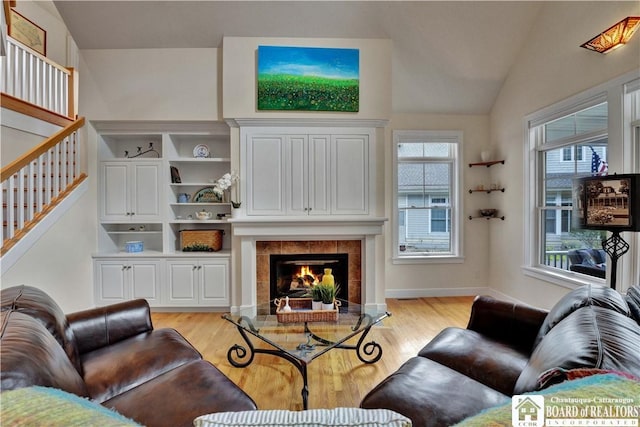 32 Howard Hanson Ave, Chautauqua, NY 14722 - living area featuring light wood-type flooring, lofted ceiling, stairway, and a tiled fireplace