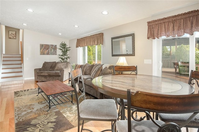 dining space with plenty of natural light, recessed lighting, stairs, light wood-style floors, and lofted ceiling