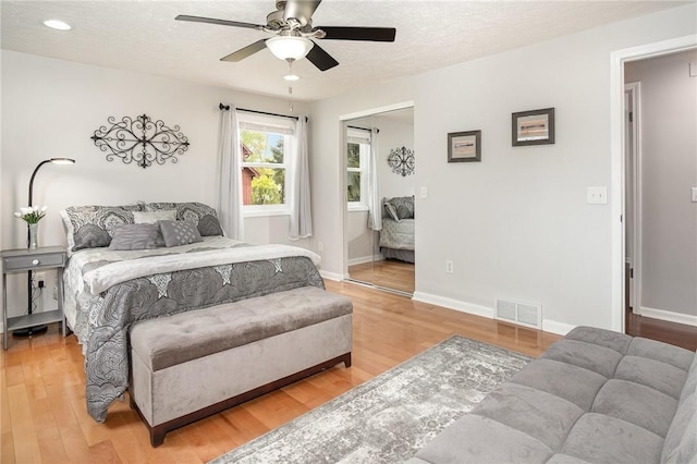 bedroom featuring light wood-style flooring, a textured ceiling, baseboards, ceiling fan, and recessed lighting
