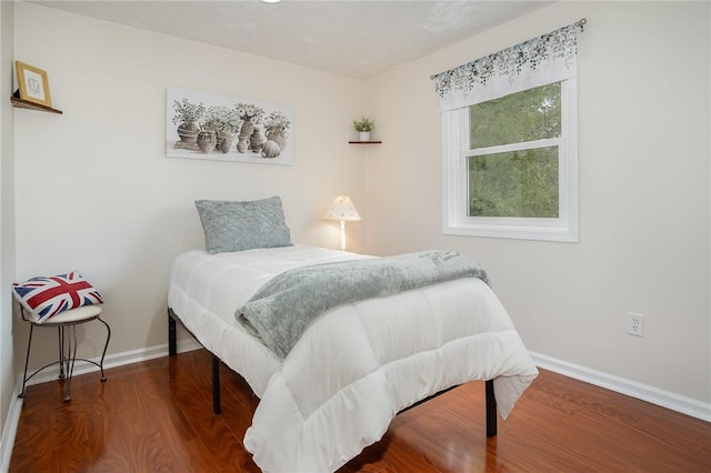 bedroom with baseboards and wood finished floors