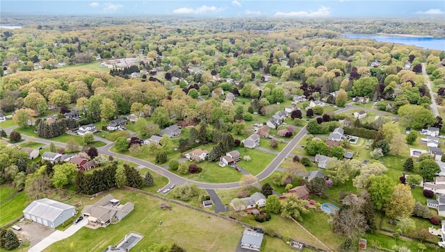 drone / aerial view of a nearby body of water and a forest