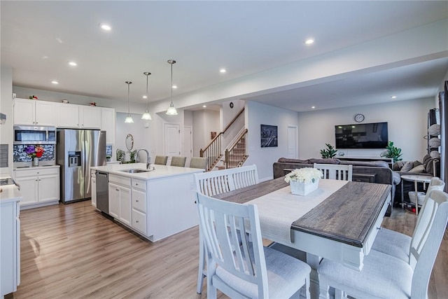 dining area with light wood-style floors, stairway, and recessed lighting