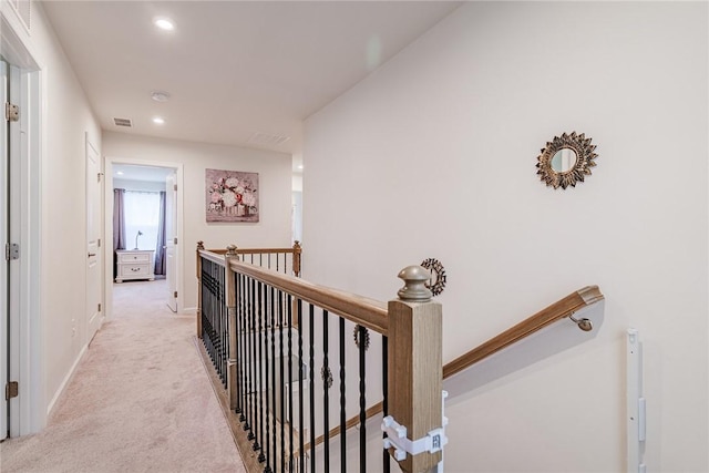 corridor with an upstairs landing, light colored carpet, recessed lighting, and baseboards