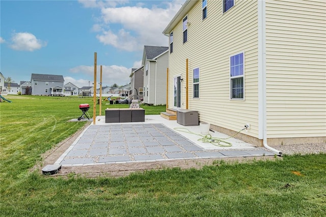 view of storm shelter featuring a patio, a lawn, a residential view, and central AC