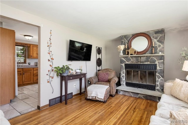 30 Schultz Rd, Orchard Park, NY 14127 - living room with light wood finished floors, a stone fireplace, and baseboards