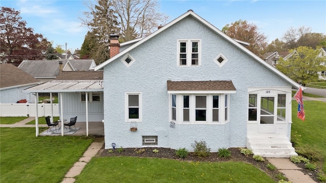 rear view of property featuring a chimney, a patio area, and roof with shingles