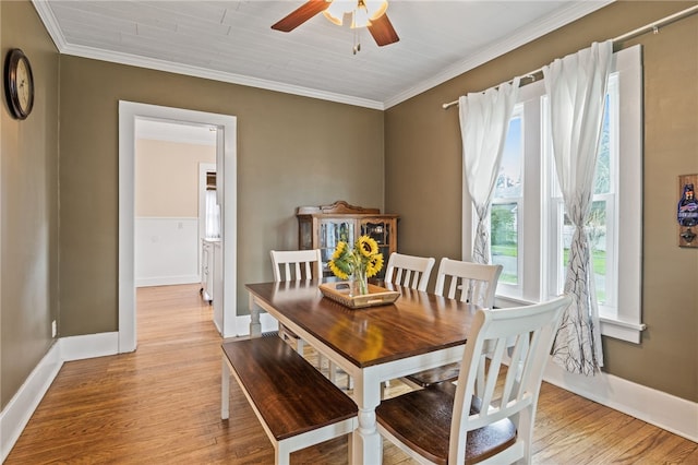 dining area featuring ceiling fan, light wood-type flooring, baseboards, and crown molding