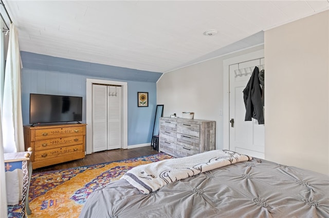 bedroom with wood finished floors, a closet, and baseboards