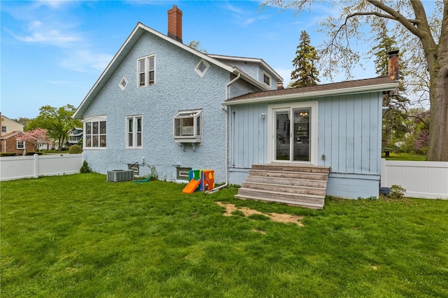 rear view of property featuring entry steps, a chimney, and central AC