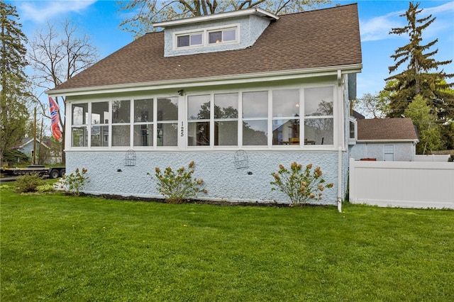 back of house with a shingled roof and a sunroom