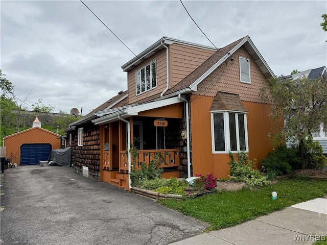 116 Fuller Ave, Tonawanda-City, NY 14150 - view of front facade with an outdoor structure, asphalt driveway, a detached garage, and a porch