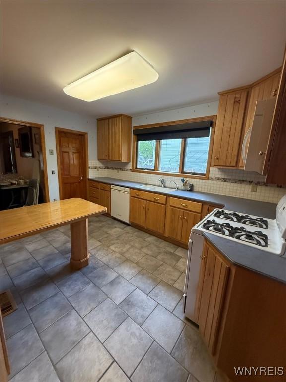 116 Fuller Ave, Tonawanda-City, NY 14150 - kitchen featuring white appliances, tasteful backsplash, a sink, and brown cabinets