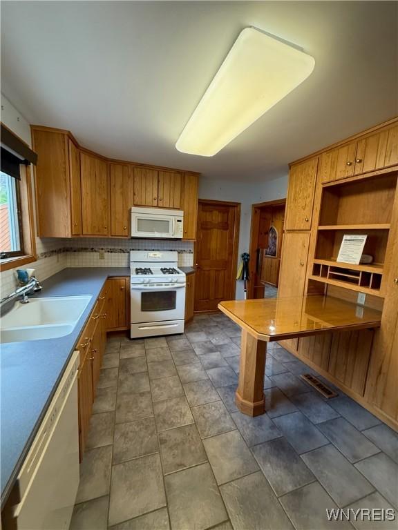 116 Fuller Ave, Tonawanda-City, NY 14150 - kitchen featuring white appliances, a sink, decorative backsplash, and brown cabinets