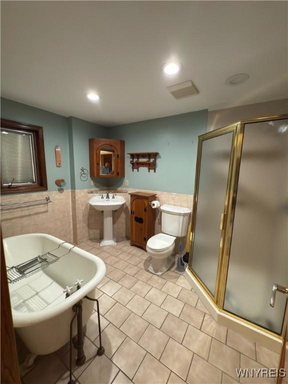 116 Fuller Ave, Tonawanda-City, NY 14150 - bathroom featuring tile walls, a wainscoted wall, a stall shower, a soaking tub, and tile patterned floors