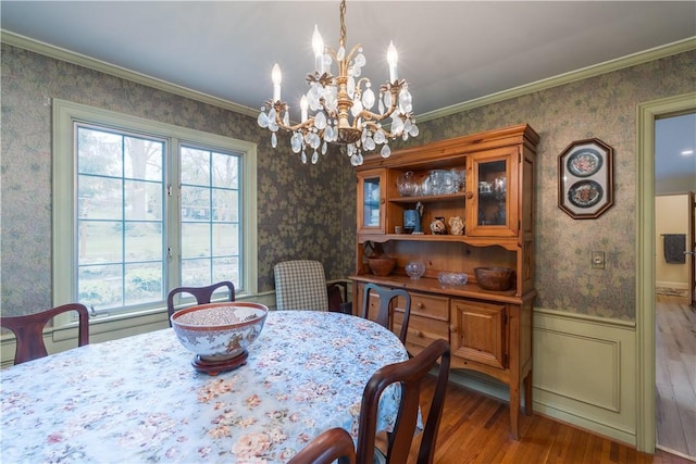 52 High St, Alfred, NY 14802 - dining room with wallpapered walls, wood finished floors, a chandelier, wainscoting, and ornamental molding