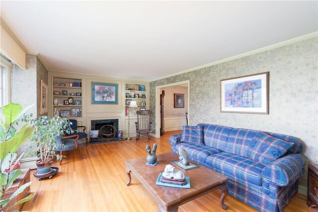 52 High St, Alfred, NY 14802 - living area with wallpapered walls, wood finished floors, crown molding, a fireplace, and built in shelves