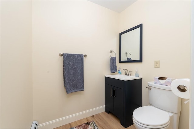 52 High St, Alfred, NY 14802 - bathroom featuring wood finished floors, vanity, toilet, baseboard heating, and baseboards