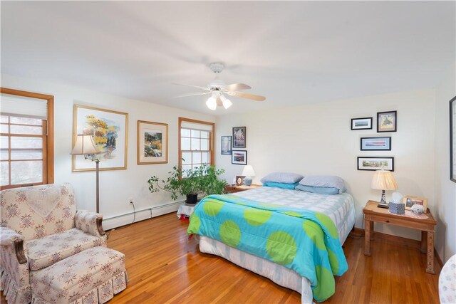 52 High St, Alfred, NY 14802 - bedroom with a baseboard heating unit, wood finished floors, baseboards, and a ceiling fan