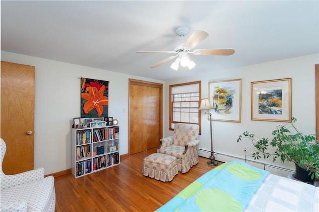52 High St, Alfred, NY 14802 - bedroom featuring wood finished floors, baseboards, baseboard heating, ceiling fan, and a closet