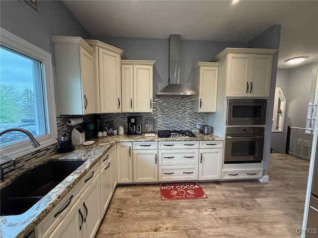1404 Riverbend Dr, Lysander, NY 13027 - kitchen with wall oven, wall chimney exhaust hood, a sink, stainless steel microwave, and light wood-type flooring