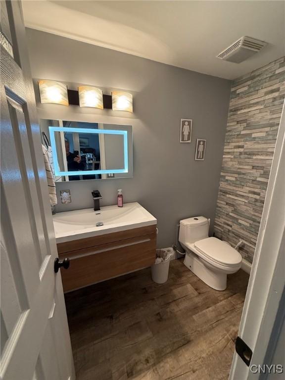 1404 Riverbend Dr, Lysander, NY 13027 - bathroom with toilet, vanity, and wood finished floors