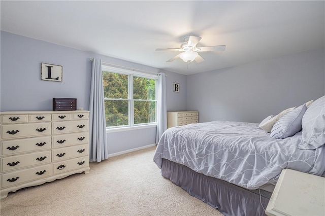 bedroom with light carpet, baseboards, and a ceiling fan
