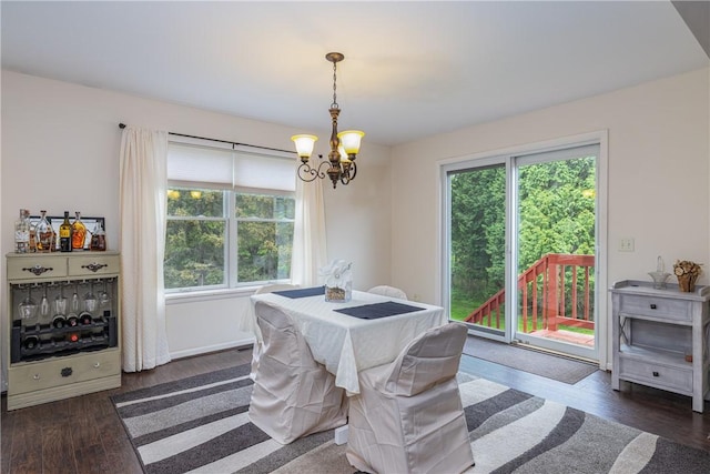dining area featuring a chandelier, dark wood-style flooring, and baseboards
