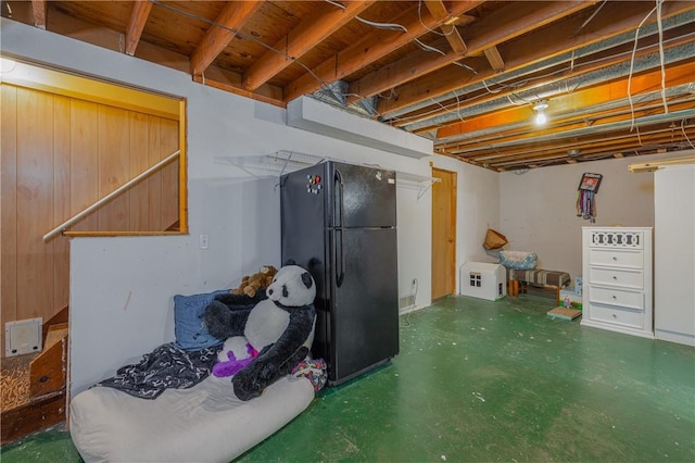 unfinished below grade area featuring freestanding refrigerator