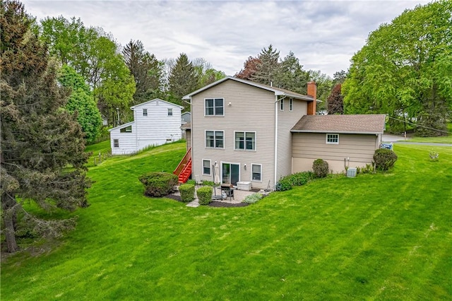 back of house with a patio area, a chimney, a lawn, central AC unit, and view of wooded area
