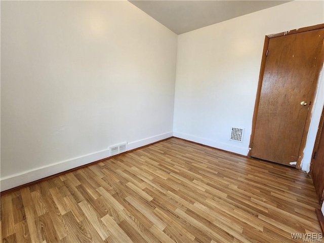 spare room featuring baseboards and light wood-type flooring
