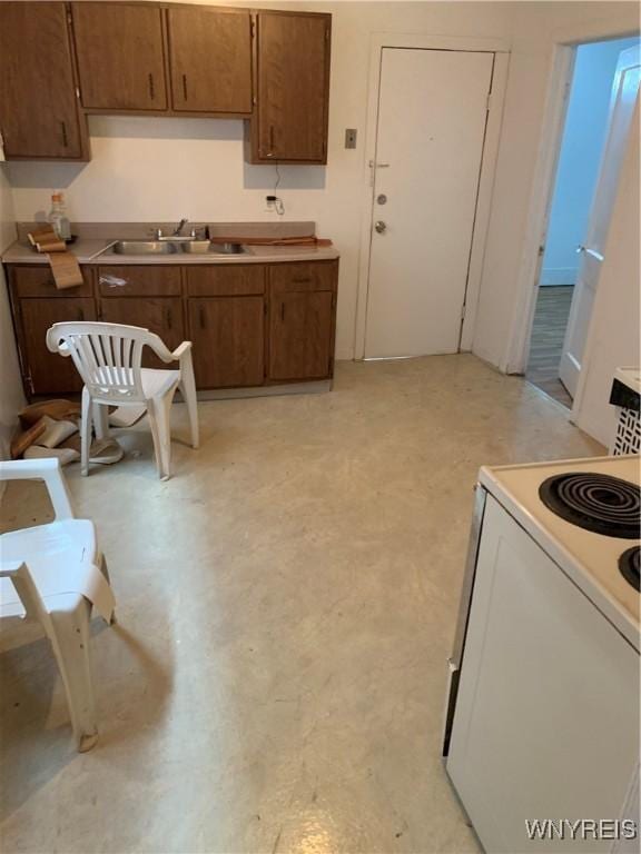 kitchen with a sink, white electric range oven, and light countertops