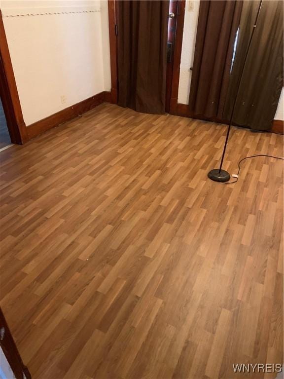 unfurnished bedroom with wood finished floors and baseboards