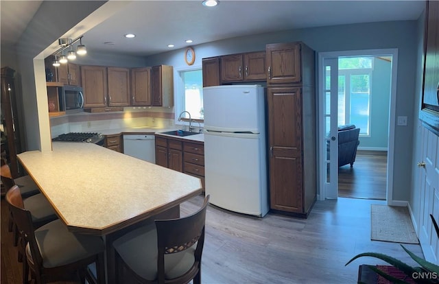 8054 Fargo Rd, Henderson, NY 13650 - kitchen with white appliances, a sink, a peninsula, light wood finished floors, and light countertops