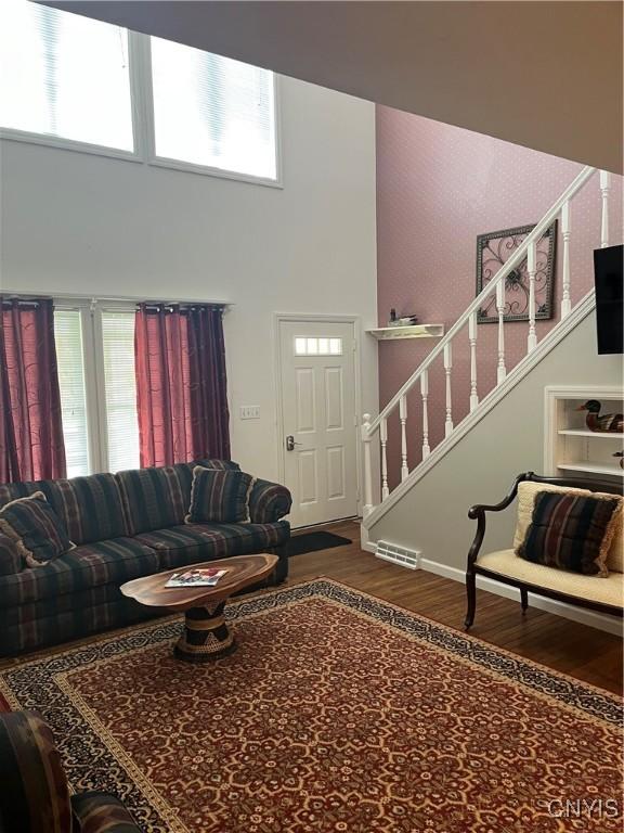 8054 Fargo Rd, Henderson, NY 13650 - living area with a high ceiling, wood finished floors, stairway, and healthy amount of natural light