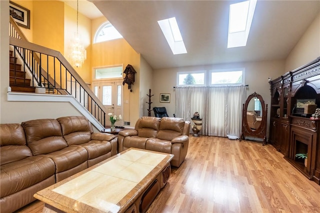 401 Montvale Ln, Greece, NY 14626 - living room with stairs, high vaulted ceiling, a chandelier, light wood-style floors, and a skylight