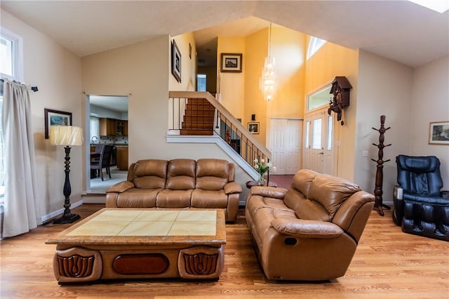 401 Montvale Ln, Greece, NY 14626 - living room featuring light wood-style flooring, stairs, high vaulted ceiling, and baseboards