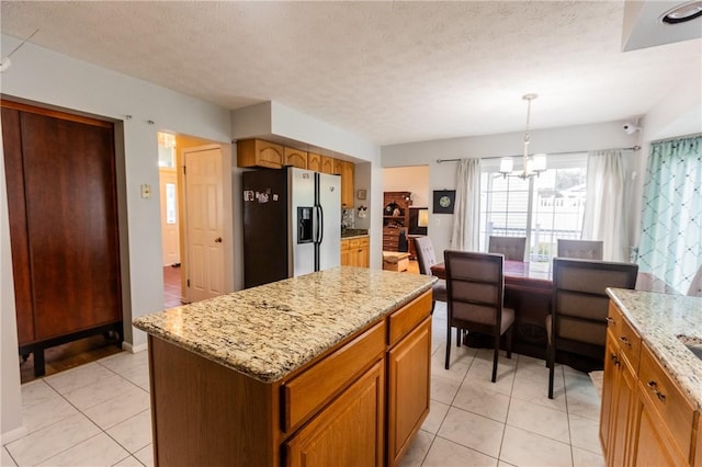 401 Montvale Ln, Greece, NY 14626 - kitchen with stainless steel fridge with ice dispenser, light tile patterned floors, a chandelier, light stone counters, and a center island
