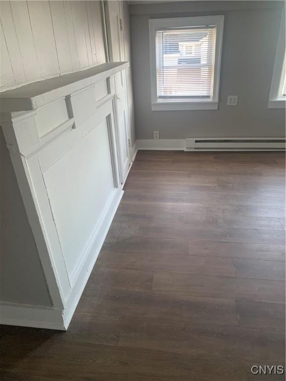 detailed view of baseboard heating, wood finished floors, and baseboards