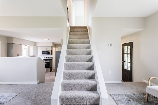 stairway featuring carpet and baseboards
