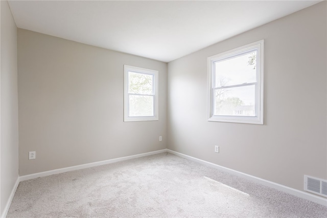 unfurnished room featuring carpet and baseboards